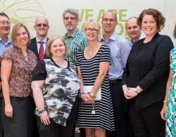 Ten committee members male and female smiling at the camera 